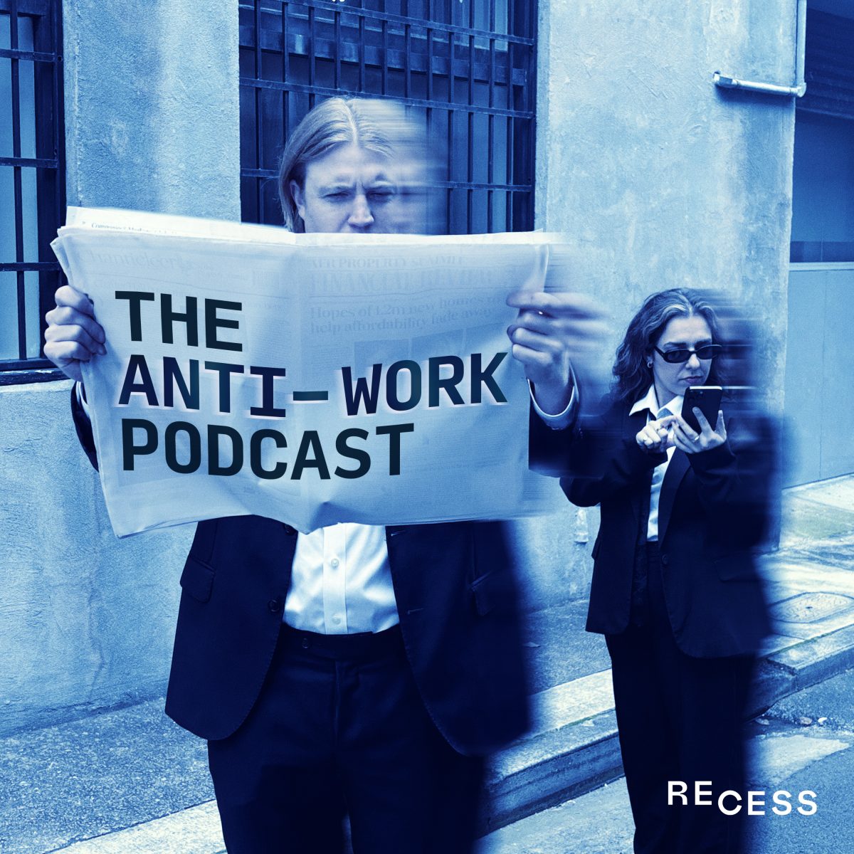 Two people in a blue tinted photo. The man in the front is holding a newspaper open in front of his face and it says "The Anti-Work Podcast". The woman behind him is looking on her phone. Both are wearing suits.